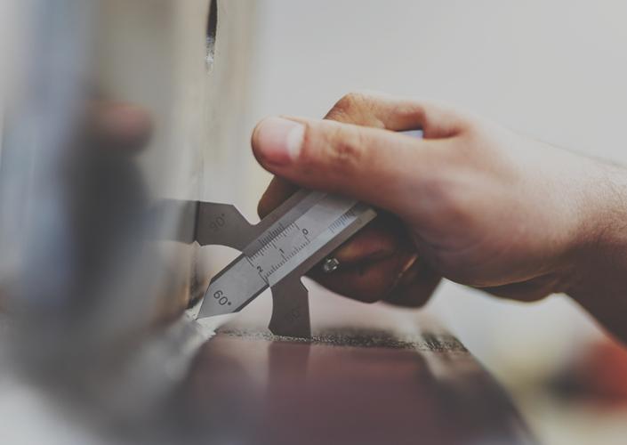 dłoń trzymająca przyrząd do pomiaru spawu